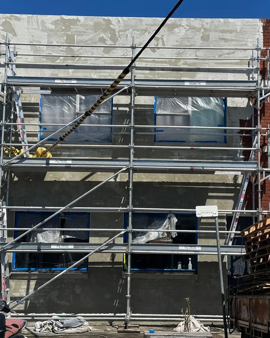 Scaffolding on a building facade being rendered